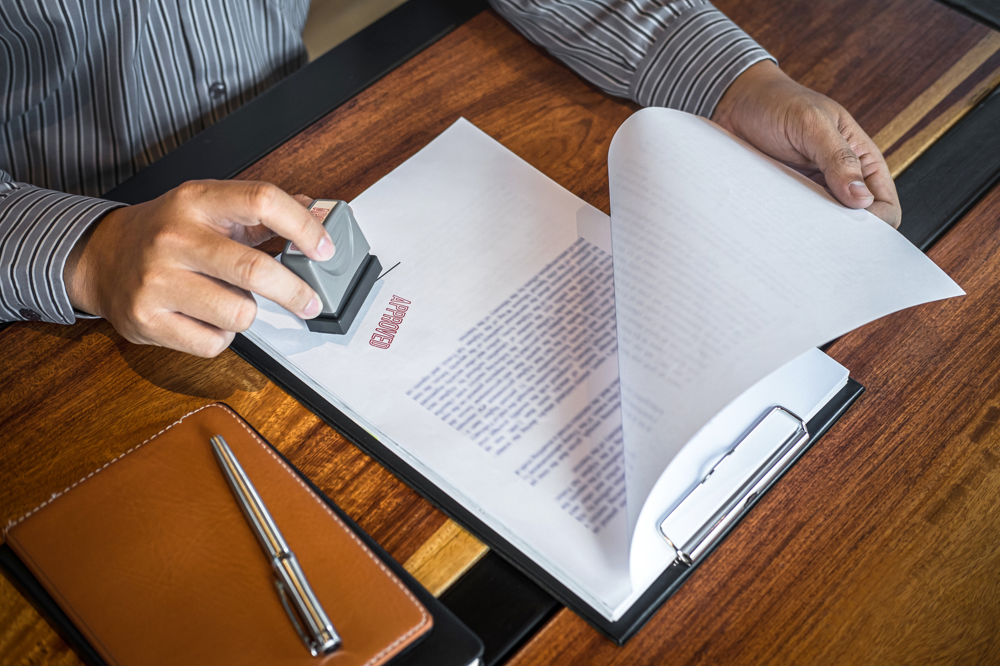 Hands of Businessman Stamp on Paper Document to Approve Business